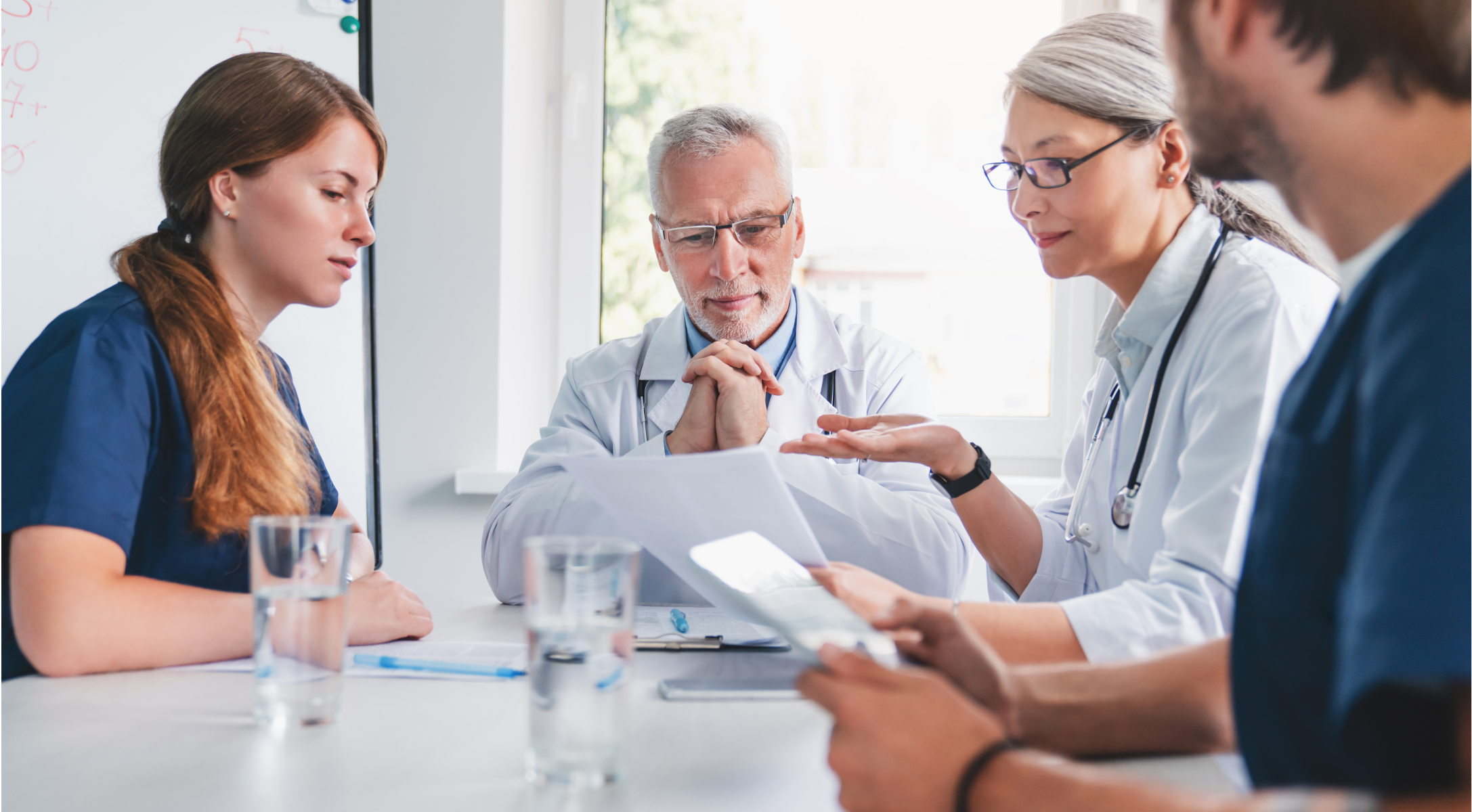 Zespół osób z personelu medycznego omawia dokumentację przy stole