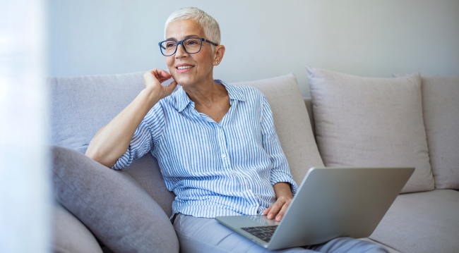 Osoba pracuje przy laptopie w domowym wnętrzu