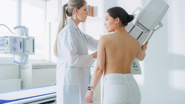 Kobieta przygotowywana do badania mammografem